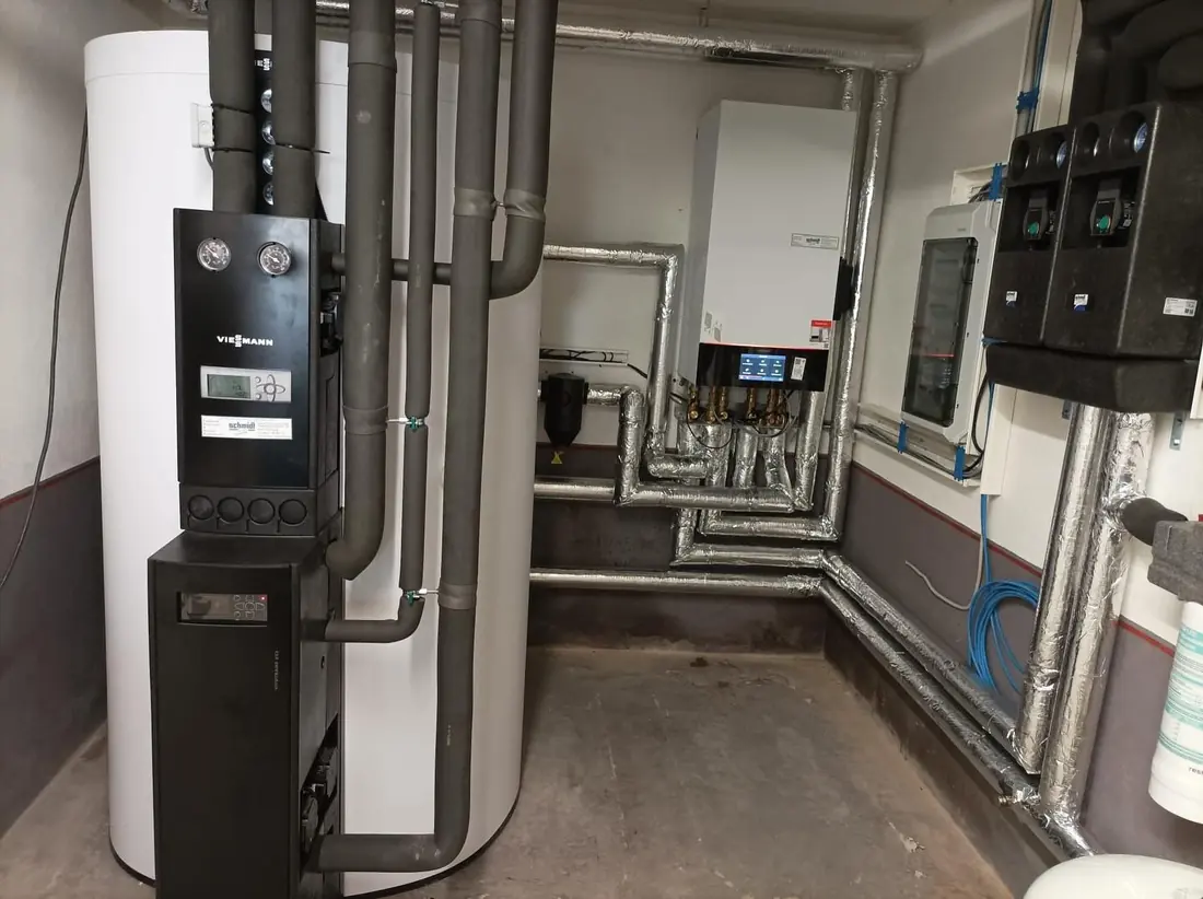 Heizzentrale mit Pufferspeicher und Verrohrung im Technikraum