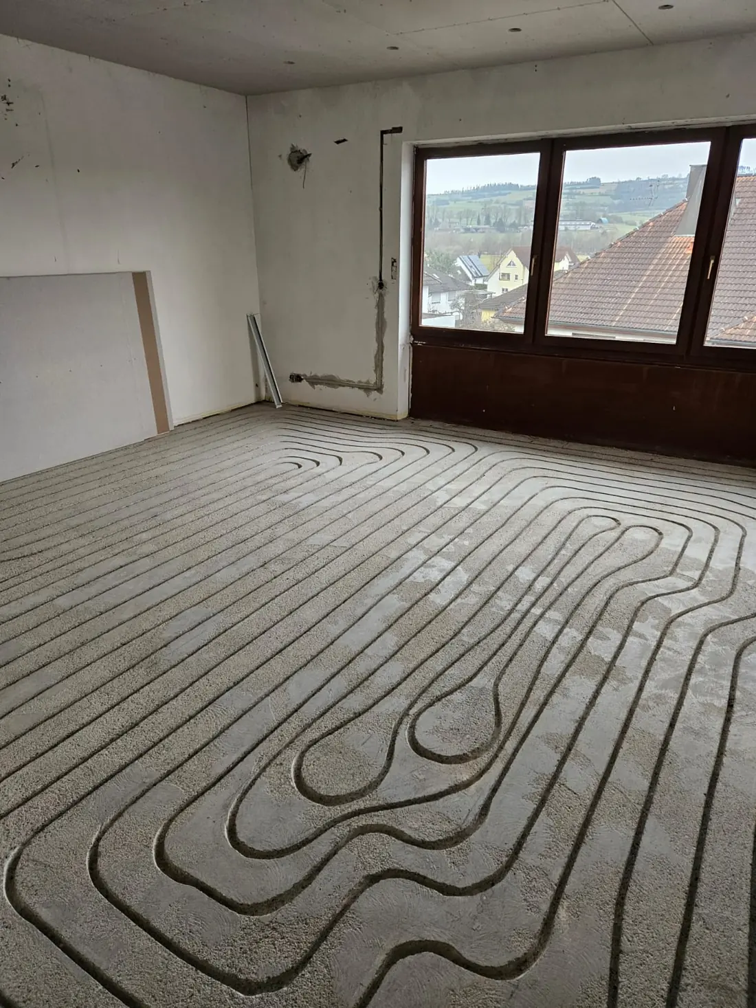 Verlegte Heizschleifen in einem Wohnraum mit Fensterfront